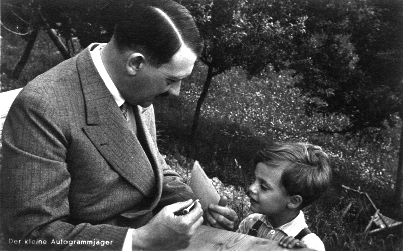 Adolf Hitler signs an autograph for a young boy on the Hochlenzer near Berchtesgaden
